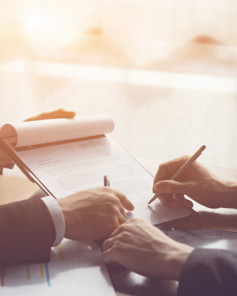 Businessperson Signing Contract about insurance, Two men writing with pen sign of modest agreements form In modern office, morning light, vintage color, success of business partners concept